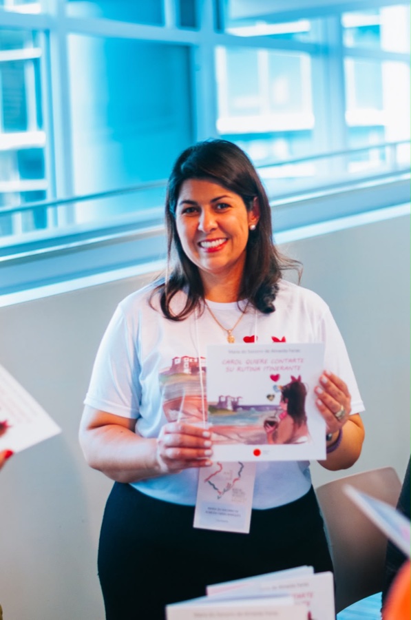 Maria do Socorro de Almeida Farias segurando o livro Carol quiere contarte su rutina itinerante