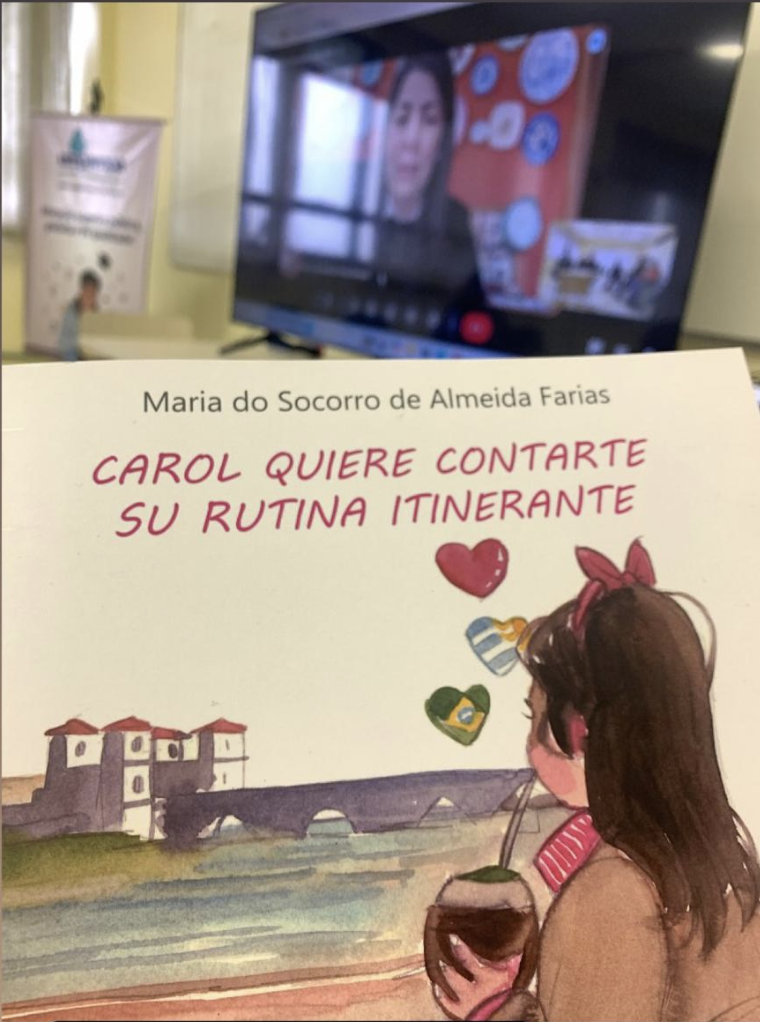Livro Carol em primeiro plano durante encontro virtual do Curso de Letras — Línguas Adicionais da UNIPAMPA Bagé